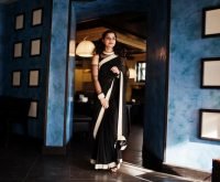 young-indian-woman-wear-elegant-black-saree-posed-restaurant-against-wall-with-frames_627829-798